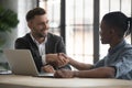 Smiling businessman shaking African American customer hand at meeting