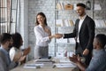 Smiling businessman shaking hand and congratulations young attractive businesswoman. Royalty Free Stock Photo