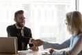 Smiling businessman shaking hand of mature businesswoman at meeting Royalty Free Stock Photo