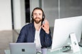 Smiling businessman show okay sign with headset interacting in his office Royalty Free Stock Photo