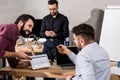 smiling businessman showing colleagues facebook page