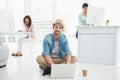 Smiling businessman sitting on the floor using laptop Royalty Free Stock Photo