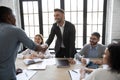 Smiling businessman in suit shaking hand of african american partner. Royalty Free Stock Photo