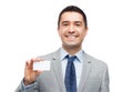 Smiling businessman in suit showing visiting card