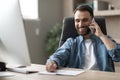 Smiling Businessman Taking Notes While Having Phone Conversation In Office Royalty Free Stock Photo