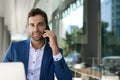 Smiling businessman talking on his cellphone at a cafe table Royalty Free Stock Photo