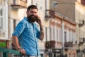 Smiling businessman talking on phone in the city. Business man using smartphone on the street. Man standing outside a Royalty Free Stock Photo