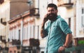 Smiling businessman talking on phone in the city. Business man using smartphone on the street. Man standing outside a Royalty Free Stock Photo