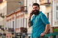 Smiling businessman talking on phone in the city. Business man using smartphone on the street. Man standing outside a Royalty Free Stock Photo