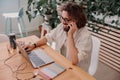 Smiling businessman talking by phone with client while working on laptop in cozy coworking Royalty Free Stock Photo