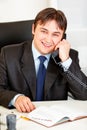 Smiling businessman talking on phone in office Royalty Free Stock Photo