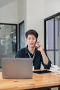 Smiling businessman talking on phone, sitting at desk with laptop, friendly manager consulting customer by phone, happy Royalty Free Stock Photo