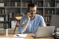 Smiling businessman talking on phone, sitting at desk with laptop Royalty Free Stock Photo