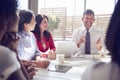 Smiling businessman talking to colleagues in a meeting room Royalty Free Stock Photo