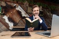 Smiling businessman thinking and reading a book in a coffeeshop Royalty Free Stock Photo