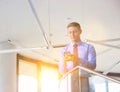 Smiling businessman using smartphone while standing at office Royalty Free Stock Photo