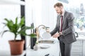 smiling businessman washing dishes in kitchen