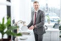 smiling businessman washing dishes in kitchen