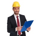 Smiling businessman wearing a protection helmet holds blue files