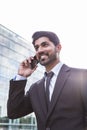 Smiling businessman or worker in suit with phone near office building Royalty Free Stock Photo