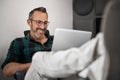 Smiling businessman working with his feet up on his desk