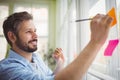 Smiling businessman writing on adhesive notes at office Royalty Free Stock Photo