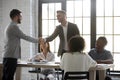 Smiling businessmen handshake closing deal at meeting Royalty Free Stock Photo