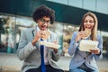 Smiling businessmen with sandwiches sitting in front of the office building Royalty Free Stock Photo