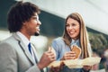 Smiling businessmen with sandwiches sitting in front of the office building Royalty Free Stock Photo