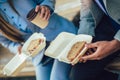 Smiling businessmen with sandwiches sitting in front of the office building Royalty Free Stock Photo