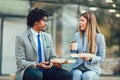 Smiling businessmen with sandwiches sitting in front of the office building Royalty Free Stock Photo