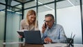 Smiling businesspeople collaborating in modern office. Businessman talking phone Royalty Free Stock Photo