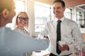 Smiling businesspeople shaking hands together over coffee Royalty Free Stock Photo