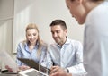 Smiling businesspeople with tablet pc in office