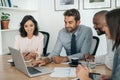 Smiling businesspeople working on a laptop together in an office Royalty Free Stock Photo