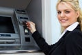 Smiling businesswoman at the ATM