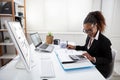 Smiling Businesswoman Calculating Invoice On Computer