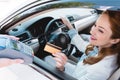 smiling businesswoman in car making payment