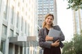 Smiling businesswoman carry laptop using wireless headphones outdoor modern city urban life concept. Positive female office worker Royalty Free Stock Photo