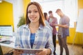 Smiling businesswoman with digital tablet standing against coworkers Royalty Free Stock Photo