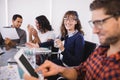 Smiling businesswoman with drinking glass sitting by colleagues Royalty Free Stock Photo