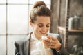 Smiling businesswoman enjoying cup of coffee latte macchiato Royalty Free Stock Photo