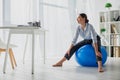 Businesswoman exercising on fitness balls in office