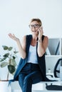 smiling businesswoman in eyeglasses gesturing by hand and talking on smartphone Royalty Free Stock Photo