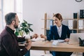 smiling businesswoman giving blank card to client with coffee to go at workplace Royalty Free Stock Photo