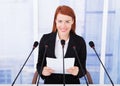 Smiling businesswoman giving speech at conference Royalty Free Stock Photo