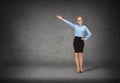 Smiling businesswoman in glasses pointing her hand Royalty Free Stock Photo