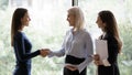 Smiling businesswoman handshake female employee in office