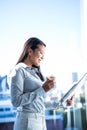 Smiling businesswoman holding disposable cup reading newspaper Royalty Free Stock Photo