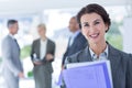 Smiling businesswoman holding files and looking at camera Royalty Free Stock Photo